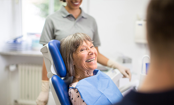 A woman sitting in a dentist chair getting her teeth cleaned.
