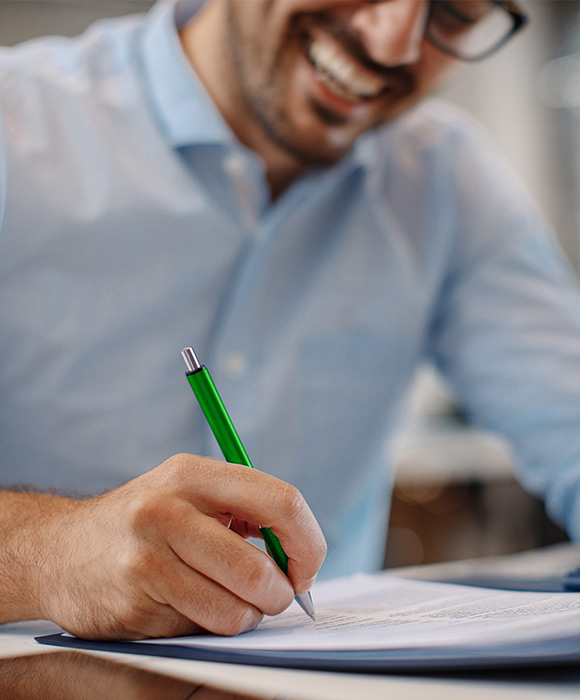 A gentleman signing a contract, working with us 